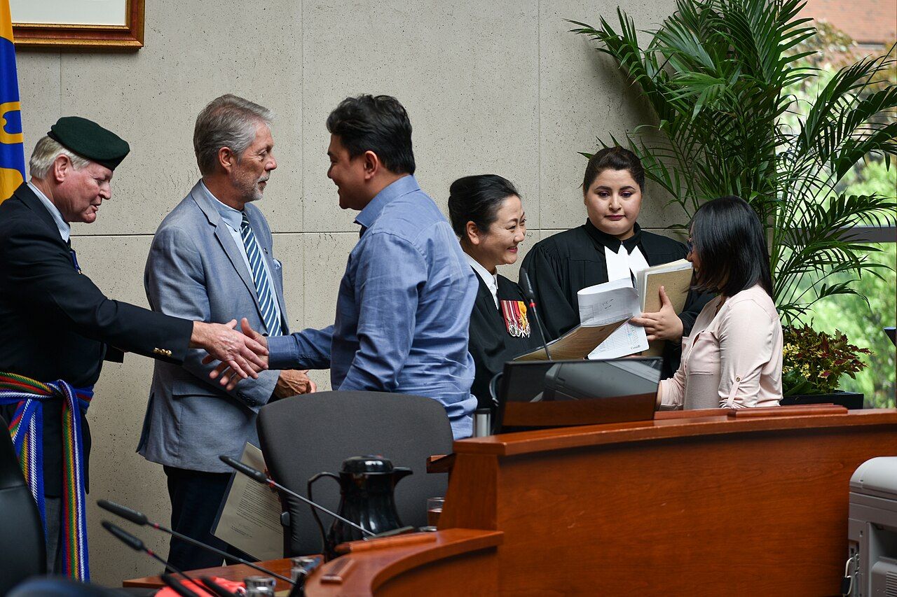 New citizens shaking hands at a citizenship ceremony in Hamilton, Ontario